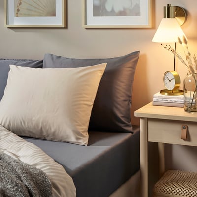 Stilvolles Schlafzimmer mit grauer Bettwäsche von NATTJASMIN, Satin-Finish, gepflegter Bettwäsche und minimalistischer Nachttischdekoration.