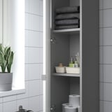 Badezimmerschrank mit offener Tür, in dem gefaltete Handtücher, Toilettenartikel und Toilettenpapierrollen auf Regalen zu sehen sind.