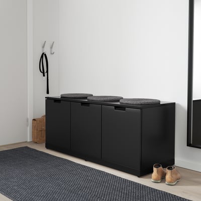 NORDLI schwarze Brustbank mit gepolstertem Sitz im Eingangsbereich.