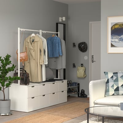 Modernes Wohnzimmer mit NORDLI Kommode, Stuhl, Pflanze und Dekor.