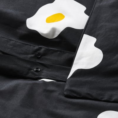 Schwarzer Bettbezug mit Sonnenblumen-Motiv und Kunststoff-Druckknopfverschluss an der Unterseite.