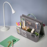 Der graue Organizer mit mehreren Fächern bietet Platz für Marker, Scheren, einen Notizblock und eine Lampe und ist für einfachen Transport und effizientes Lernen konzipiert.