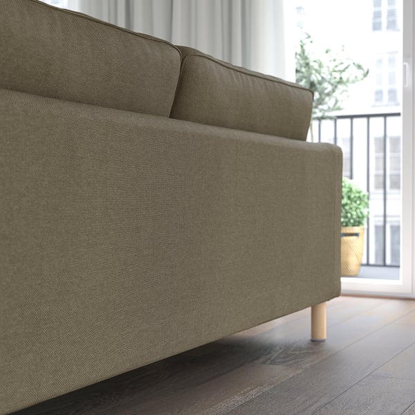 Modernes graues Sofa mit Holzbeinen, in der Nähe eines Fensters, gemütlicher und abnehmbarer Bezug.