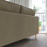 Modernes graues Sofa mit Holzbeinen, in der Nähe eines Fensters, gemütlicher und abnehmbarer Bezug.