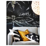 Das PÄRUP-Sofa mit bunten Kissen vor einer fetten, schwarzen Wand mit weißem Graffiti.