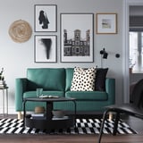 Modernes Wohnzimmer mit grünem PÄRUP-Sofa, schwarz-weißen Kissen, Couchtisch, gestreiftem Teppich und Wandkunstgalerie.
