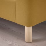 Olivgrünes Sofa, klare Linien; Beine aus hellem Holz, polierte Oberfläche; auf Holzboden gestellt.
