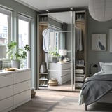 Modernes Schlafzimmer mit PAX-Kleiderschränken und Pflanzen.