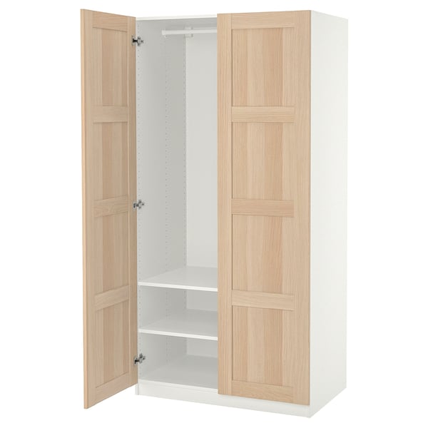 Ein offener ikea PAX Kleiderschrank. Es ist hellbeige mit Holzpaneelen, einem weißen Interieur und zwei verstellbaren Regalen.