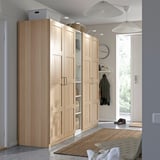 Großer PAX-Kleiderschrank aus hellem Holz am Eingang, hoch mit mehreren Fächern zur Aufbewahrung, minimalistisches Design.