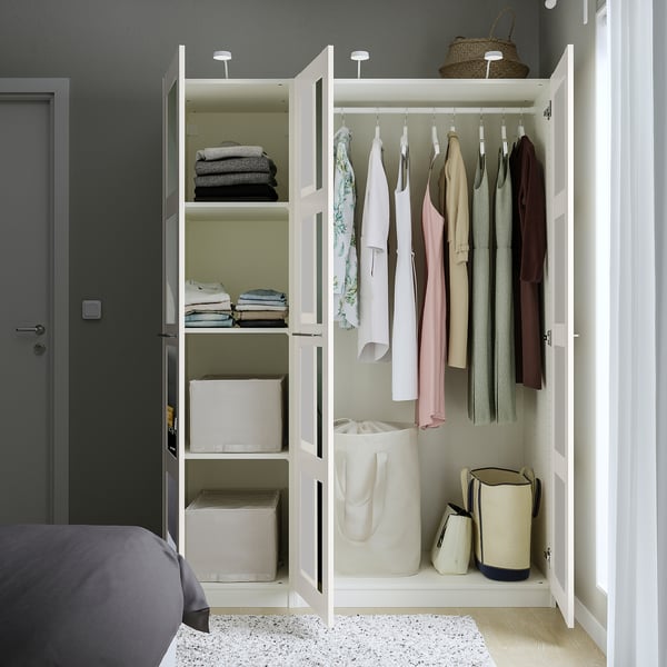 Offener weißer PAX-Kleiderschrank mit Kleidung und Accessoires.