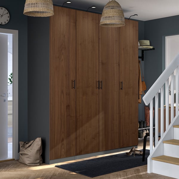 Moderner Eingangsbereich mit großem PAX-Kleiderschrank aus braunem Holz, Hängelampen, weißer Treppe, Garderobe und schwarzer Matte.