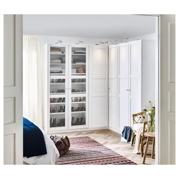 Weißer PAX-Kleiderschrank mit Glastüren und Regalen in minimalistischem Raum