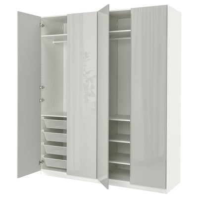 Ein weißer Ikea PAX-Kleiderschrank mit offenen Türen, in denen Regale und Netzkörbe zu sehen sind.