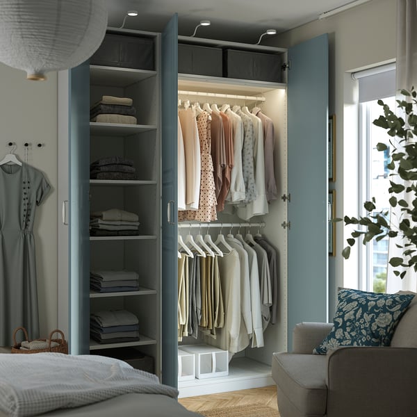 Ein gut organisierter Kleiderschrank mit verspiegelten Türen und Regalen, in dem ordentlich gefaltete Kleidung und hängende Kleidungsstücke präsentiert werden.
