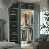 Ein gut organisierter Kleiderschrank mit verspiegelten Türen und Regalen, in dem ordentlich gefaltete Kleidung und hängende Kleidungsstücke präsentiert werden.