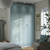 Modernes Schlafzimmer mit hohem grau-blauem PAX-Kleiderschrank, viel Stauraum und stilvoller Einrichtung. Der Kleiderschrank ist der größte Gegenstand im Zimmer.