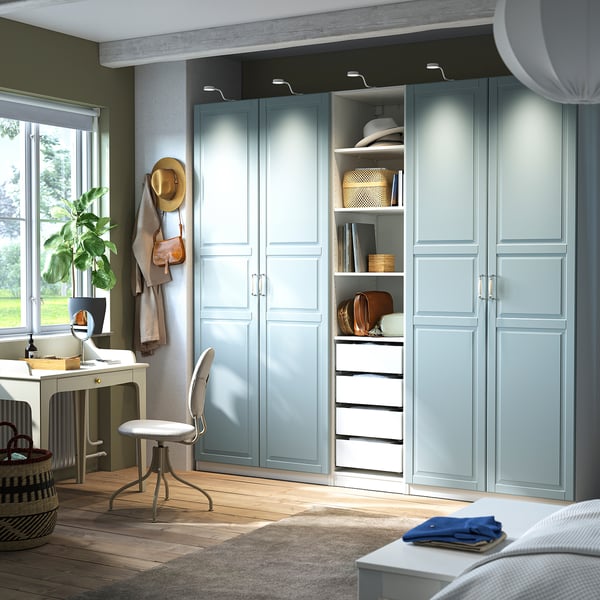 Großer hellblauer PAX-Kleiderschrank, höher als Schreibtisch und Stuhl, mit offenen Regalen, Hut und Geldbörsen.