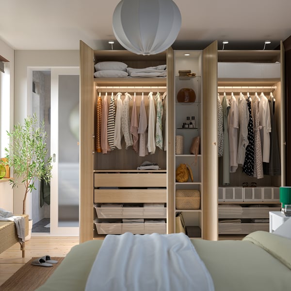 Modernes, organisiertes Schlafzimmer mit PAX-Kleiderschrank . Die Kleidung hängt ordentlich, mit Regalen und Schubladen zur Aufbewahrung.