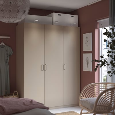 Modernes Schlafzimmer mit beigem PAX-Kleiderschrank, Tageslicht, stilvollem Dekor und minimalistischem Design.