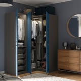 Offener blauer Kleiderschrank mit Kleidung, Handtüchern und Regalen, Wandbeleuchtung. Oder blauer Kleiderschrank offen, in dem Kleidung, Handtücher, Regale und Wandbeleuchtung zu sehen sind.