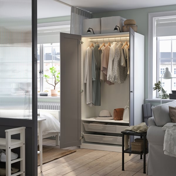 Modernes Wohnzimmer mit PAX-Kleiderschrank, Sofa und Schreibtisch.
