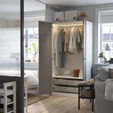Modernes Wohnzimmer mit PAX-Kleiderschrank, Sofa und Schreibtisch.