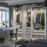 Schlafzimmer mit weißem PAX-Kleiderschrank, Stuhl, Schreibtisch und Fenster.