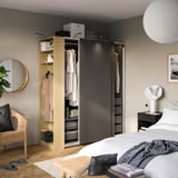 Schlafzimmer mit PAX-Kleiderschrank mit hängender Kleidung, Regalen mit Accessoires und Schiebetüren.