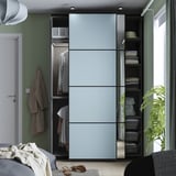 Moderner Kleiderschrank mit Schiebetüren, der organisierte Kleidung und Stauraum zeigt.