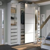 Ein gut organisierter, weißer PAX-Kleiderschrank mit Schiebetüren, Regalen und Schubladen. Moderne, funktionale Aufbewahrungslösung mit einem klaren, minimalistischen Design.