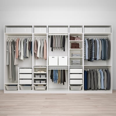 Organisierter begehbarer Kleiderschrank mit Hängevorhang, Schubladen, Regalen und Stauraum.