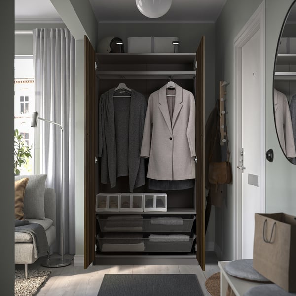 Offener Kleiderschrank mit Jacken und Schubladen, gezeigt in einem modernen Zimmer mit grauem Dekor.