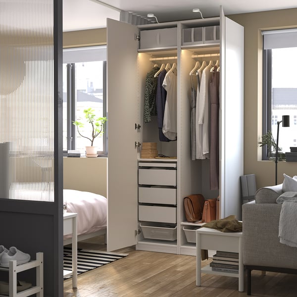 Modernes Schlafzimmer mit offenem PAX-Kleiderschrank mit Kleidung, Schubladen und Innenbeleuchtung.