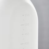 Weiße Sprühflasche mit Messwerten von 400 bis 550 ml auf einer gebogenen Seite vor einem grauen Hintergrund.