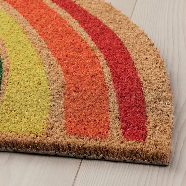 Bunt gestreifte Fußmatte auf hellem Holzboden.