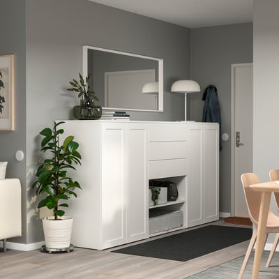 Modernes graues Wohnzimmer mit großem PLATSA-Stauraum, Schubladen, Pflanze, Lampe, Spiegel und Vase.