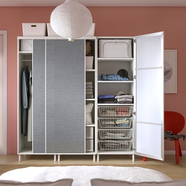 Moderner Aufbewahrungsschrank mit Schiebetüren, Regalen und Aufhängestange, gut organisiert für Kleidung und Accessoires, an einer rosa Wand.