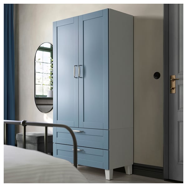 Blauer PLATSA-Kleiderschrank mit Schubladen und Türen an der Schlafzimmerwand.