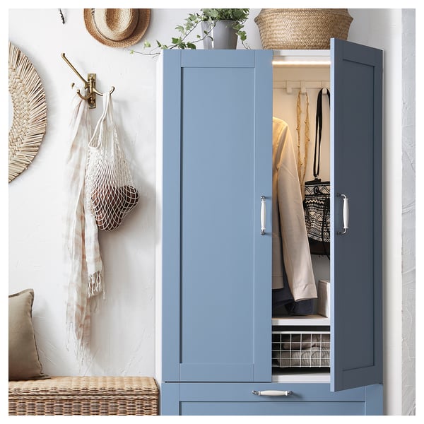 Blauer PLATSA-Kleiderschrank mit Kleidung und Accessoires, mit schlankem Design und organisiertem Stauraum.