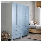 Großer blauer Kleiderschrank mit Griffen. Vier Schubladen, zwei Türen. Moderne Schlafzimmereinrichtung.