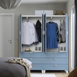 Schlafzimmer mit hellblauem PLATSA-Kleiderschrank mit Kleiderbügeln, Schubladen und Kleidung.