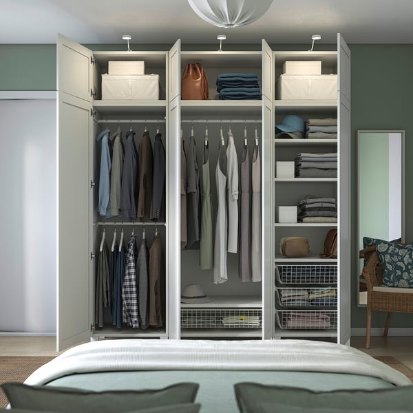 Offener Schlafzimmerschrank mit Kleiderbügeln, Regalen mit gefalteter Kleidung, Taschen und Aufbewahrungsbehältern. Organisiert mit verstellbaren Innenorganisationen.