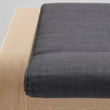 Nahaufnahme eines modernen, stilvollen Fußhockers mit glattem Stoff und robustem Holzrahmen, der hochwertiges Design und Handwerkskunst zeigt.