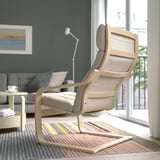 Modernes Wohnzimmer mit POÄNG Sessel, Stadtblick und grauem Sofa.