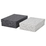 Zwei rechteckige Aufbewahrungsboxen, eine schwarze und eine weiße, beide mit gepunkteten Mustern. Hergestellt aus recyceltem Karton. Ideal zum Organisieren von Schreibtischartikeln.