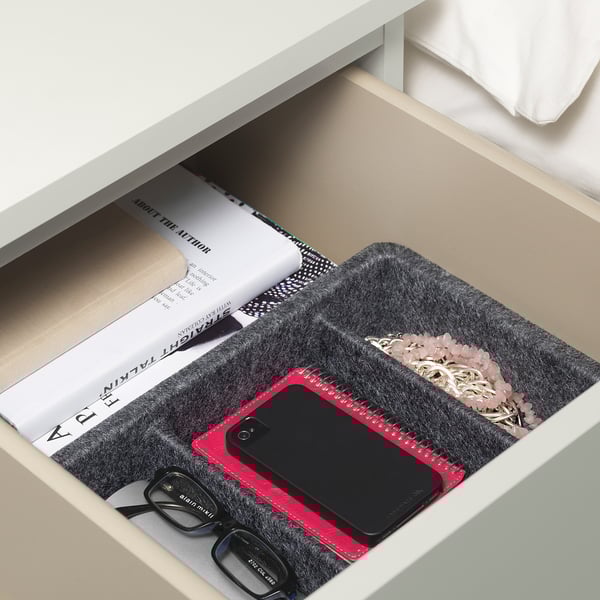 Offene Schublade mit Filztabletts zum Organisieren von Gläsern, Telefon, Buch und Schmuck.