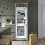 Offener Kühlschrank mit verstellbaren Regalen, LED-Licht und transparenten Fächern. Gemüse, Gläser und Getränke sind sichtbar.