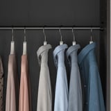 Kleiderschrank mit hängenden Hemden in Beige-, Grau- und Blautönen mit Kleiderstange und platzsparendem Design.