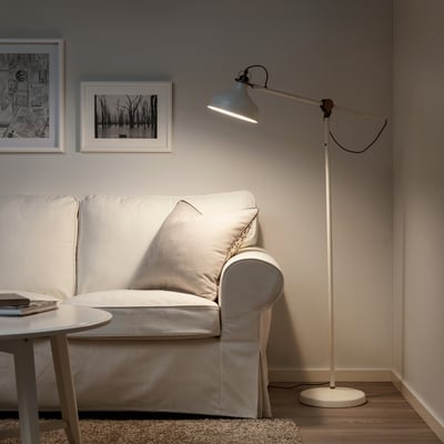 Modernes Wohnzimmer mit RANASP-Lampe über grauem Sofa, Schwarz-Weiß-Kunst.